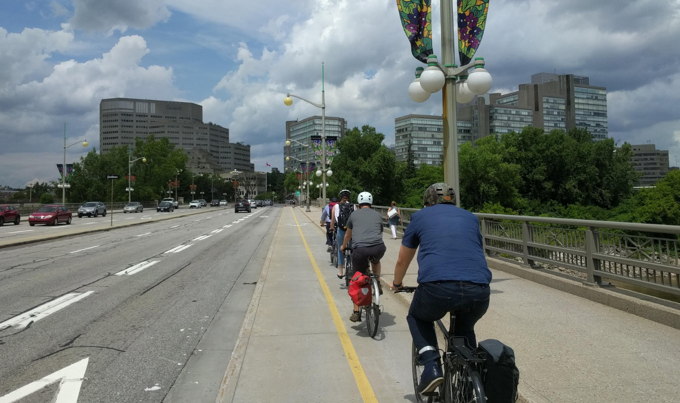 A photo of public servants bicycling together across the Portage bridge between Ottawa and Gatineau.
